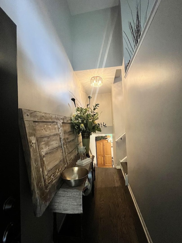 corridor with wood finished floors and a high ceiling