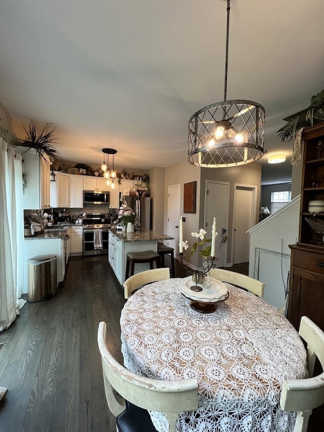 dining area featuring dark wood-style floors and a chandelier