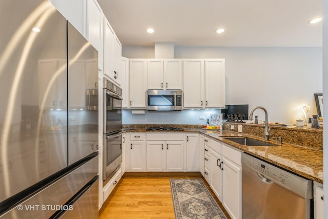 49 W 15th St Unit D, Chicago, IL 60605 - kitchen with stainless steel appliances, white cabinets, dark stone counters, light wood-style flooring, and recessed lighting