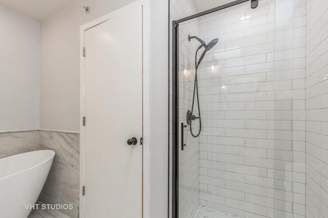 49 W 15th St Unit D, Chicago, IL 60605 - bathroom featuring a shower stall, a freestanding tub, wainscoting, and tile walls