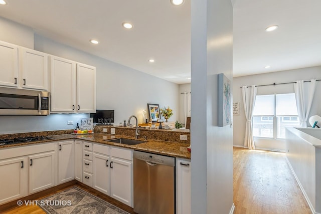49 W 15th St Unit D, Chicago, IL 60605 - kitchen featuring stainless steel appliances, recessed lighting, dark stone countertops, white cabinetry, and light wood-style flooring