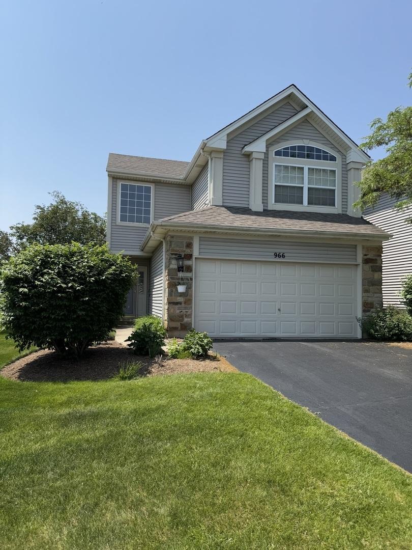 966 Mesa Dr, Lake In The Hills, IL 60156 - view of front facade featuring stone siding, driveway, a front lawn, and an attached garage