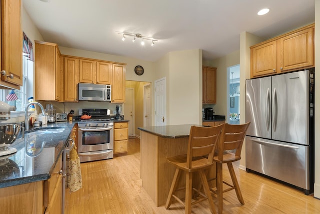 910 Angle Tarn Dr, West Dundee, IL 60118 - kitchen featuring appliances with stainless steel finishes, light wood-type flooring, a center island, dark stone counters, and recessed lighting