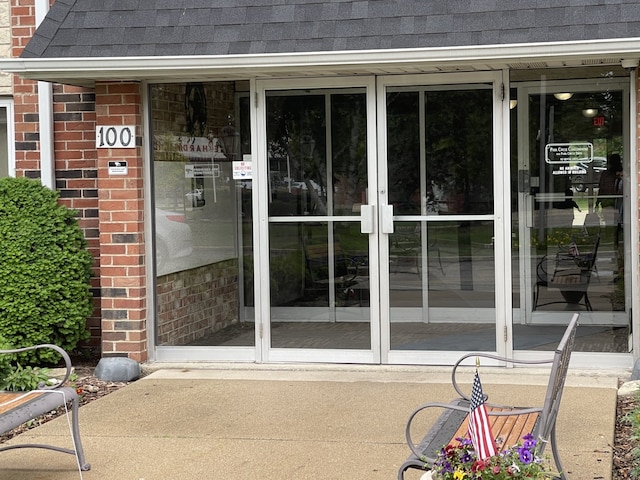100 W Park Circle Dr Unit 2I, Wheaton, IL 60187 - view of exterior entry with a shingled roof and brick siding