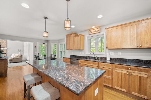 1826 Joseph Sixbury St, Sycamore, IL 60178 - kitchen with stainless steel dishwasher, light wood-type flooring, a kitchen island, a breakfast bar, and dark stone counters