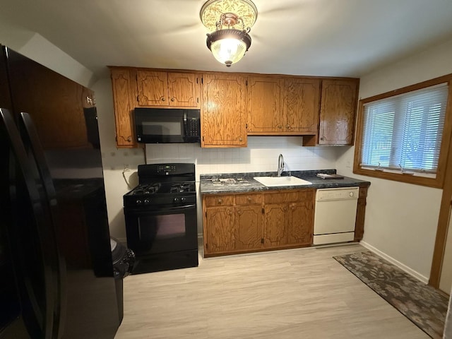 215 Krotiak Rd, Park Forest, IL 60466 - kitchen featuring black appliances, dark countertops, backsplash, and brown cabinetry