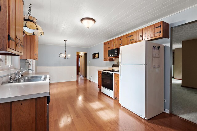 25725 S Old Monee Steger Rd, Monee, IL 60449 - kitchen with white appliances, brown cabinetry, a chandelier, light wood-type flooring, and light countertops