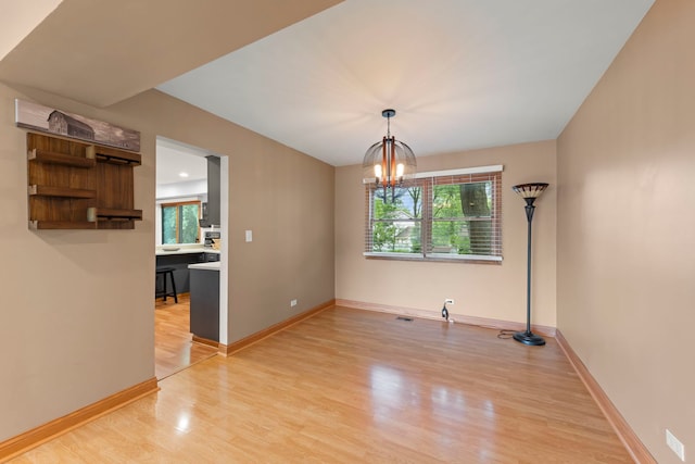 573 Surryse Rd, Lake Zurich, IL 60047 - unfurnished dining area with light wood-style floors, healthy amount of natural light, and a chandelier