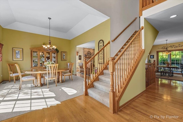 3720 Cypress Dr, Spring Grove, IL 60081 - stairway featuring wood finished floors, a chandelier, and a raised ceiling