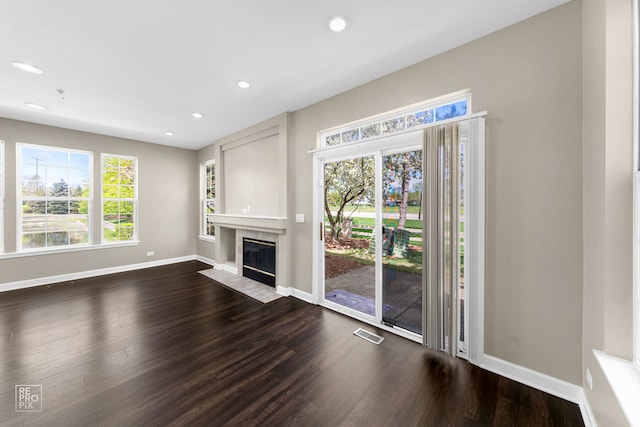 2673 N Greenwood Ave, Arlington Heights, IL 60004 - unfurnished living room with dark wood-style flooring, a tiled fireplace, and recessed lighting