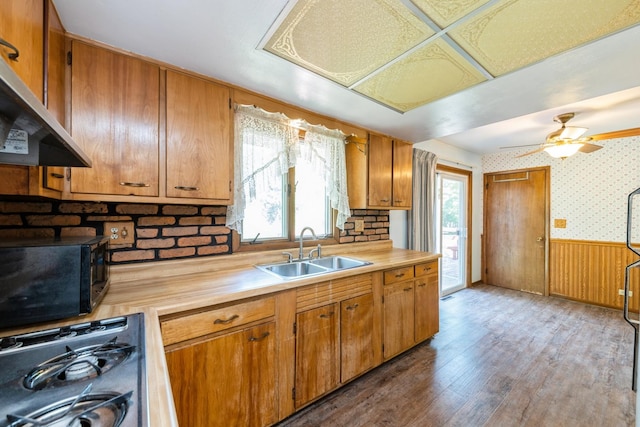 184 Kathleen Dr, Elgin, IL 60123 - kitchen featuring range hood, black microwave, wood finished floors, brown cabinets, and wainscoting