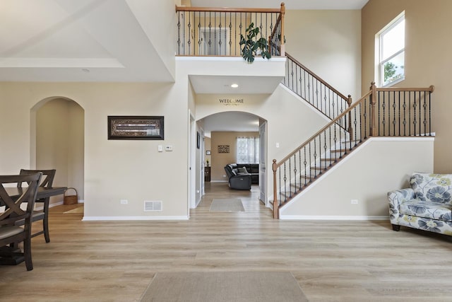 60 Linden Rd, Lake Zurich, IL 60047 - foyer entrance with arched walkways, healthy amount of natural light, wood finished floors, stairway, and a towering ceiling