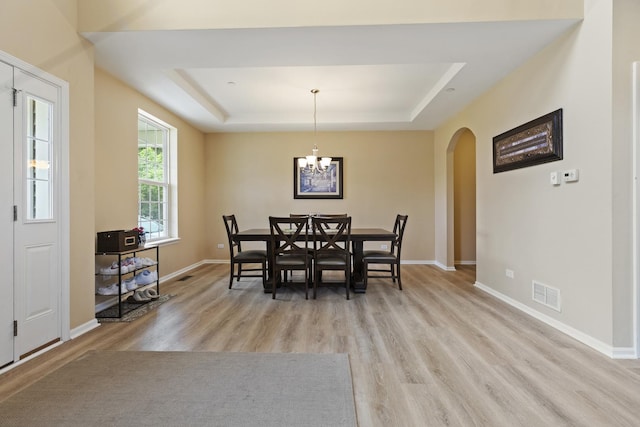 60 Linden Rd, Lake Zurich, IL 60047 - dining area featuring a raised ceiling, arched walkways, light wood finished floors, and a chandelier