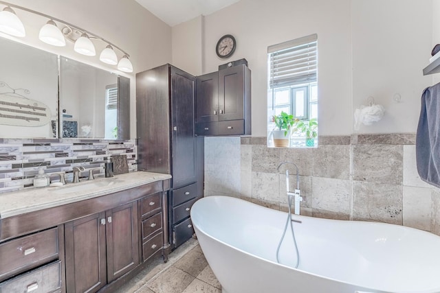 3605 W Cermak Rd, Chicago, IL 60623 - bathroom featuring a freestanding bath, vanity, tile walls, and tasteful backsplash