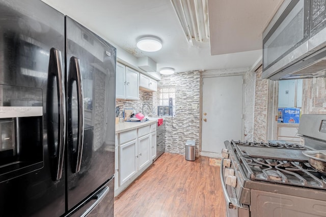 3605 W Cermak Rd, Chicago, IL 60623 - kitchen featuring stainless steel appliances, light wood-style floors, white cabinetry, and light countertops
