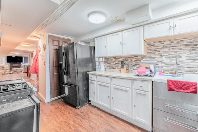 3605 W Cermak Rd, Chicago, IL 60623 - kitchen featuring black fridge with ice dispenser, light wood-type flooring, white cabinets, backsplash, and light countertops