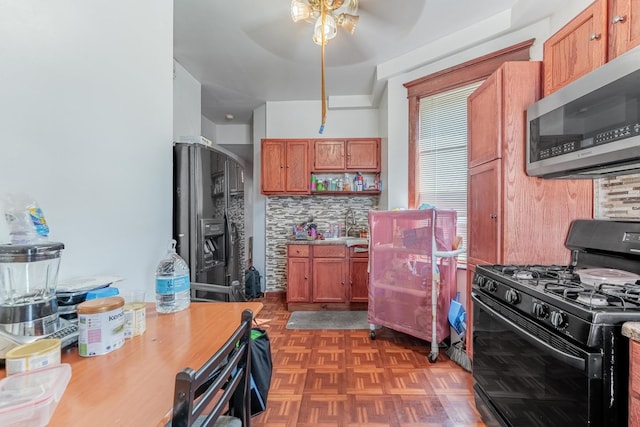 3605 W Cermak Rd, Chicago, IL 60623 - kitchen featuring stainless steel microwave, black gas range oven, ceiling fan, backsplash, and fridge with ice dispenser