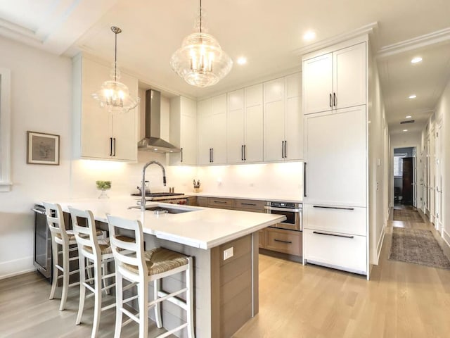 2745 N Greenview Ave Unit 2, Chicago, IL 60614 - kitchen featuring wall chimney range hood, a chandelier, light wood-style flooring, a peninsula, and recessed lighting