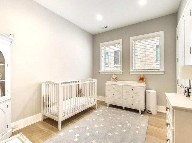 2745 N Greenview Ave Unit 2, Chicago, IL 60614 - bedroom with light wood-style floors, a crib, and recessed lighting