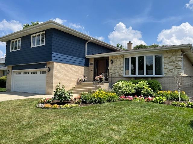 769 S Stuart Ave, Elmhurst, IL 60126 - tri-level home with a chimney, a front yard, driveway, and stone siding