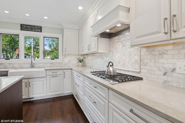 769 S Stuart Ave, Elmhurst, IL 60126 - kitchen with stainless steel gas cooktop, premium range hood, white cabinets, ornamental molding, and light stone counters