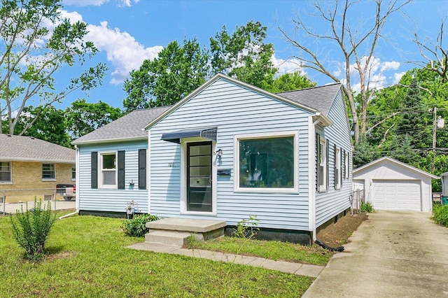 1211 Garden Ln, Champaign, IL 61820 - bungalow featuring a detached garage, an outbuilding, concrete driveway, and roof with shingles