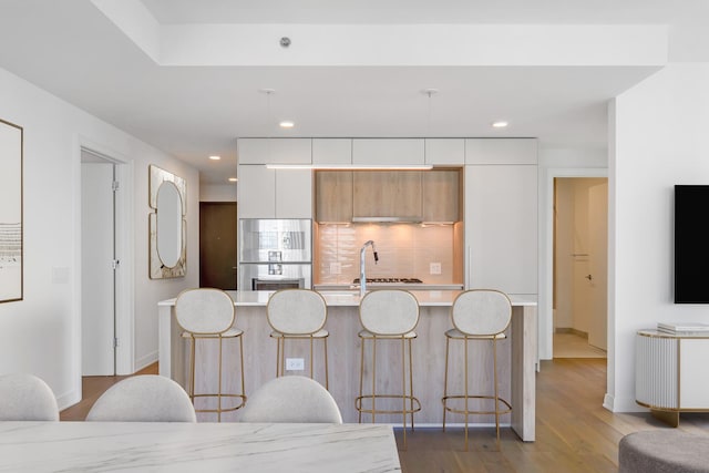 211 N Harbor Dr Unit 1601, Chicago, IL 60601 - kitchen with light countertops, a breakfast bar area, wood finished floors, modern cabinets, and white cabinetry
