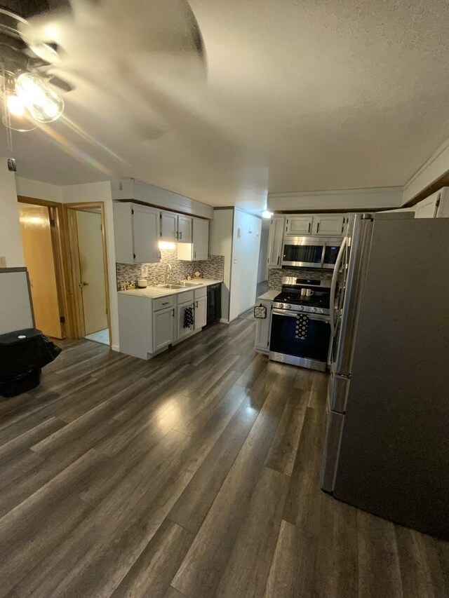14441 Dante Ave, Dolton, IL 60419 - kitchen with appliances with stainless steel finishes, light countertops, a ceiling fan, backsplash, and dark wood-style floors