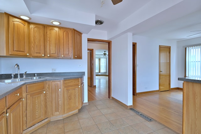 5010 N Merrimac Ave, Chicago, IL 60630 - kitchen with a ceiling fan, light tile patterned floors, and brown cabinetry