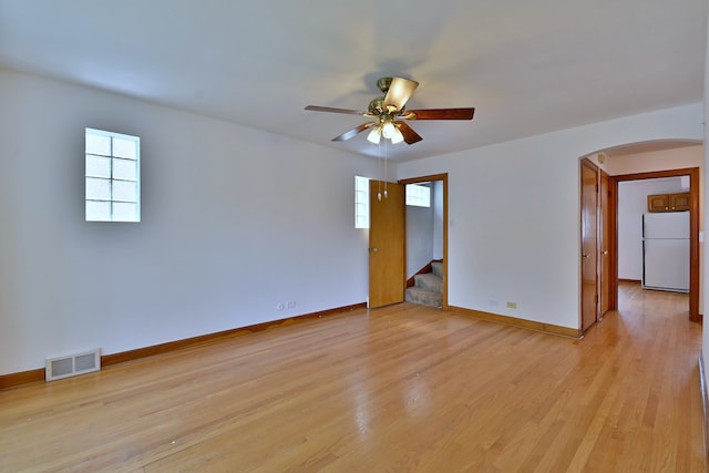 5010 N Merrimac Ave, Chicago, IL 60630 - empty room with arched walkways, stairway, healthy amount of natural light, and a ceiling fan