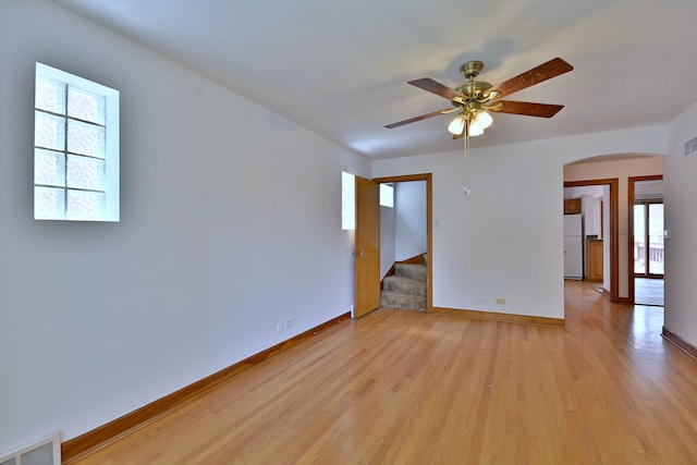 5010 N Merrimac Ave, Chicago, IL 60630 - spare room featuring arched walkways, light wood-style flooring, stairs, and a ceiling fan