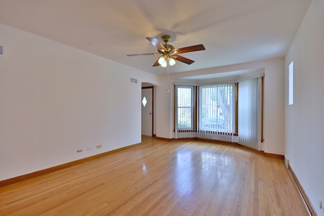 5010 N Merrimac Ave, Chicago, IL 60630 - empty room featuring arched walkways, ceiling fan, and light wood finished floors