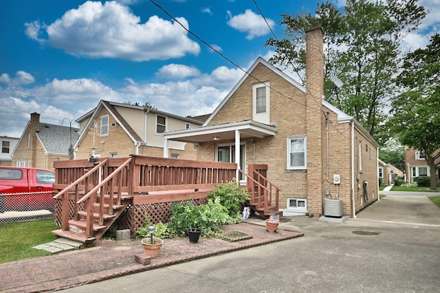 5010 N Merrimac Ave, Chicago, IL 60630 - rear view of property with a chimney, brick siding, a deck, and stairway