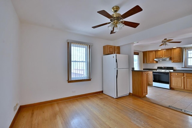5010 N Merrimac Ave, Chicago, IL 60630 - kitchen with white appliances, under cabinet range hood, dark countertops, light wood-type flooring, and ceiling fan