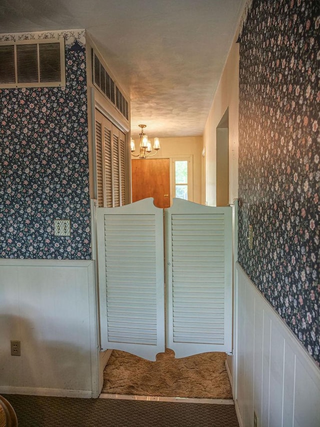 110 Hickory, Villa Grove, IL 61956 - stairway featuring wallpapered walls, a wainscoted wall, and a chandelier