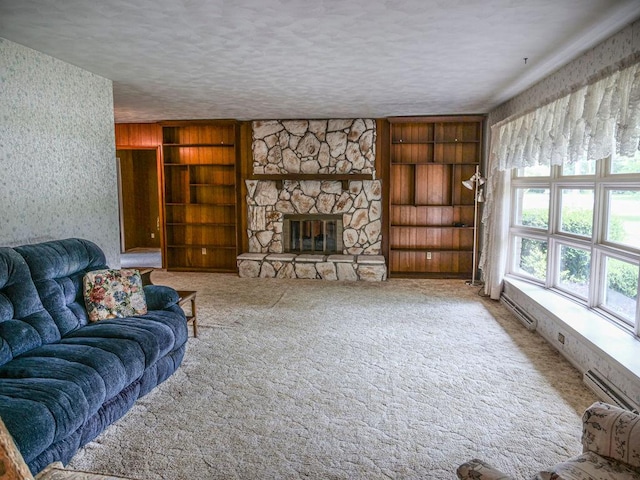110 Hickory, Villa Grove, IL 61956 - carpeted living area with a stone fireplace, built in features, a textured ceiling, wallpapered walls, and a baseboard heating unit