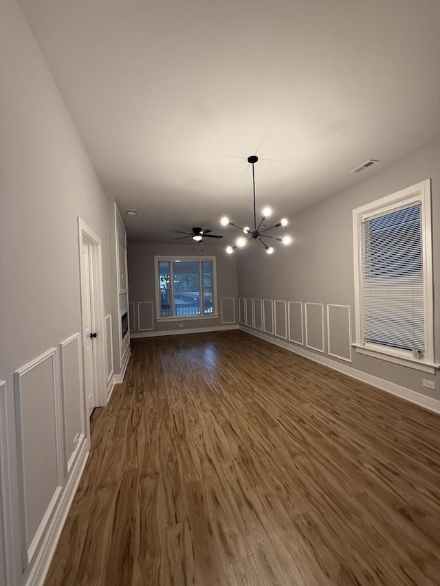 7130 S Morgan St, Chicago, IL 60621 - empty room with dark wood-style floors, a chandelier, and a decorative wall