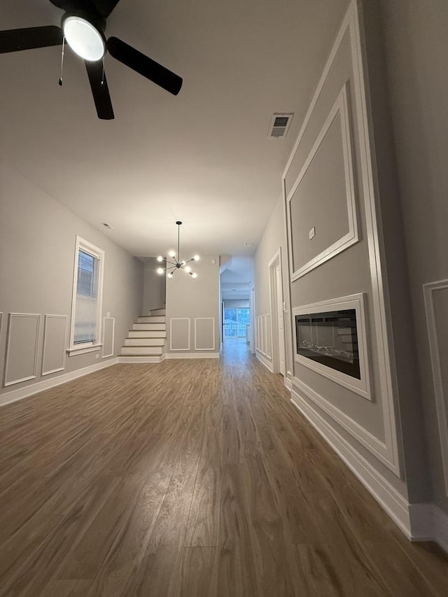 7130 S Morgan St, Chicago, IL 60621 - unfurnished living room with ceiling fan, dark wood finished floors, a glass covered fireplace, a decorative wall, and stairs