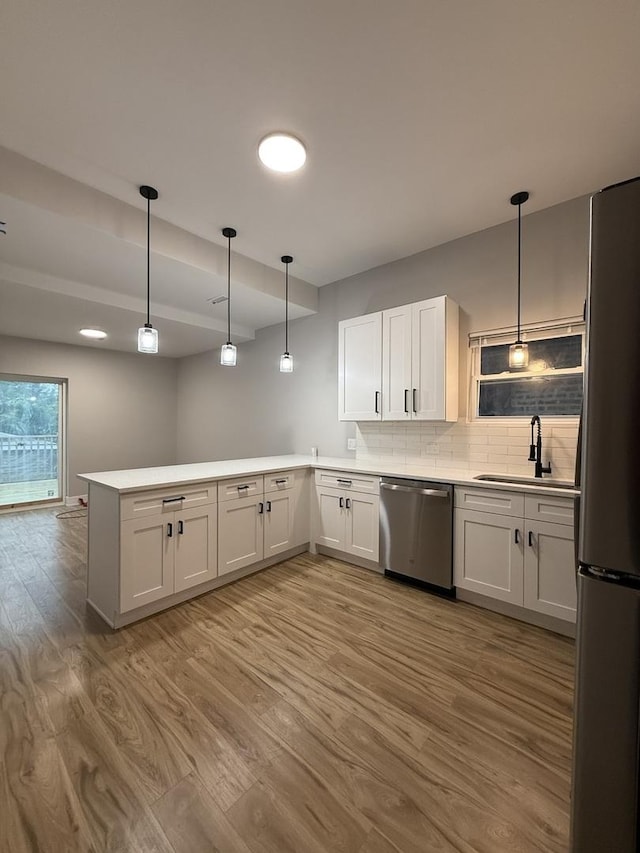 7130 S Morgan St, Chicago, IL 60621 - kitchen with stainless steel appliances, wood finished floors, a peninsula, decorative backsplash, and light countertops