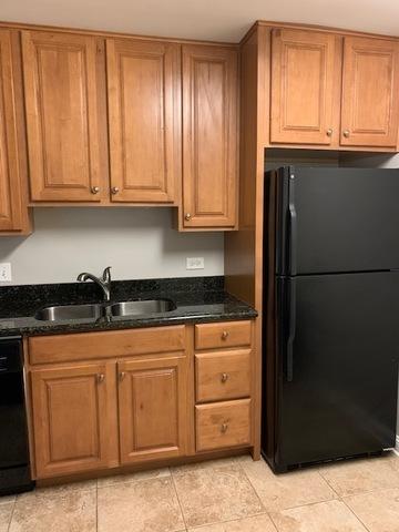 1919 S Wolf Rd Unit 1-322, Hillside, IL 60162 - kitchen featuring black appliances, dark stone counters, brown cabinets, and light tile patterned floors