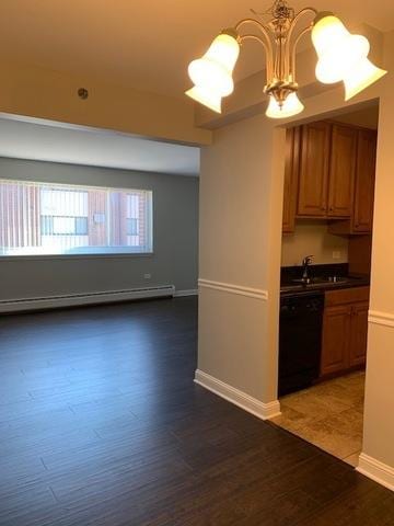 1919 S Wolf Rd Unit 1-322, Hillside, IL 60162 - kitchen with black dishwasher, baseboard heating, a chandelier, wood finished floors, and brown cabinetry