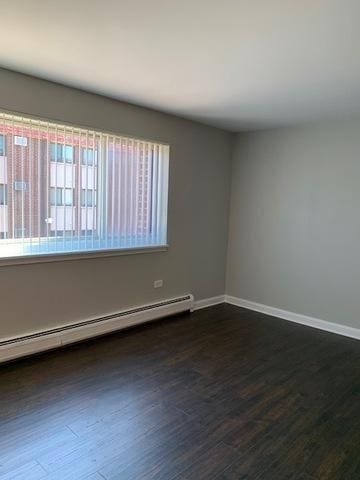 1919 S Wolf Rd Unit 1-322, Hillside, IL 60162 - spare room with a baseboard heating unit, healthy amount of natural light, and dark wood finished floors