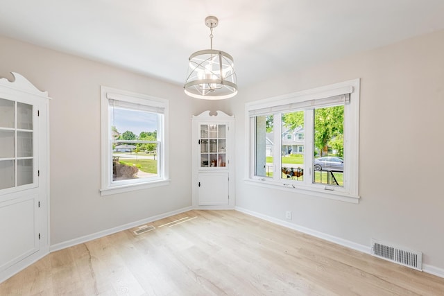 19749 Mokena St, Mokena, IL 60448 - unfurnished dining area featuring light wood-type flooring, plenty of natural light, and a chandelier