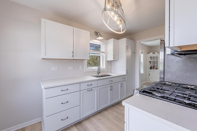 19749 Mokena St, Mokena, IL 60448 - kitchen featuring white cabinetry, light countertops, light wood-type flooring, and pendant lighting