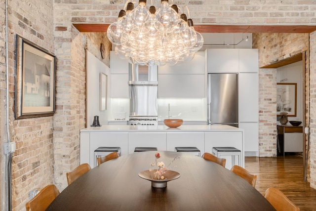 1017 W Washington Blvd Unit 2H, Chicago, IL 60607 - dining space featuring brick wall, wood finished floors, and a chandelier