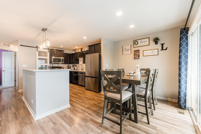 1113 Sapphire Ln, Pingree Grove, IL 60140 - kitchen featuring appliances with stainless steel finishes, dark brown cabinetry, light countertops, tasteful backsplash, and light wood-style floors
