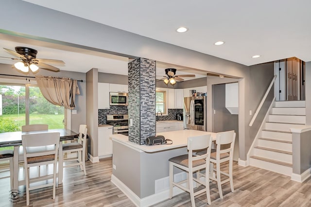 17242 Odell Ave, Tinley Park, IL 60477 - kitchen featuring stainless steel appliances, a ceiling fan, decorative backsplash, white cabinets, and light wood finished floors