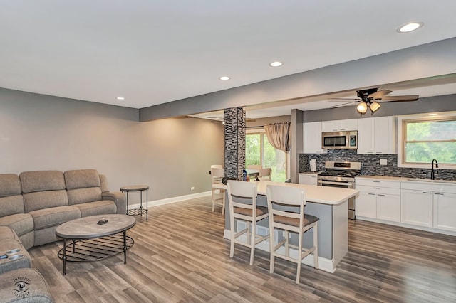 17242 Odell Ave, Tinley Park, IL 60477 - kitchen featuring stainless steel appliances, open floor plan, a breakfast bar, white cabinets, and wood finished floors