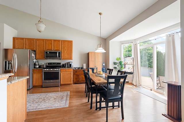 1611 Wintercrest Ln, Shorewood, IL 60404 - kitchen featuring stainless steel appliances, high vaulted ceiling, decorative light fixtures, light wood finished floors, and brown cabinetry