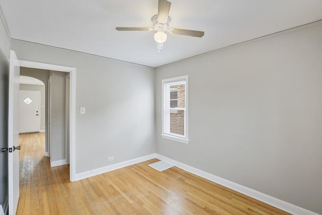 6000 S Mayfield Ave, Chicago, IL 60638 - empty room featuring light wood-style flooring, a ceiling fan, and arched walkways